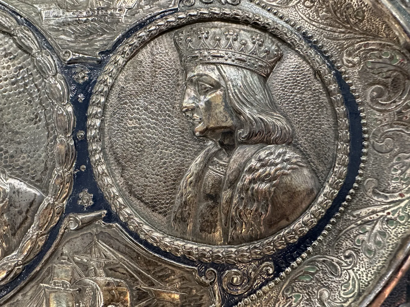 Plaque murale antique avec l'image d'un roi et des détails ornés.