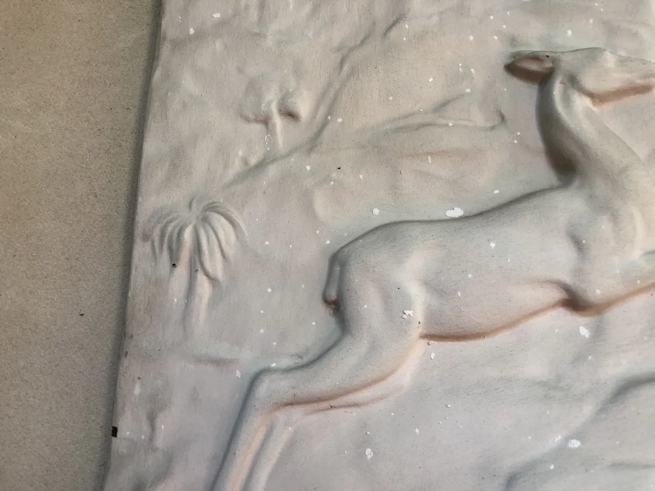 Plaque murale ancienne avec un chevreuil et des palmiers