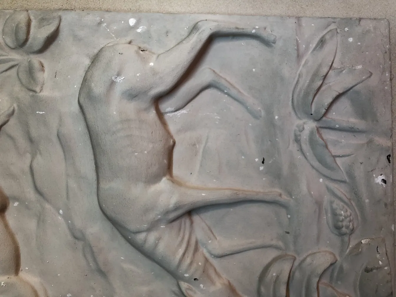 Plaque murale ancienne avec détails en relief et décoration.