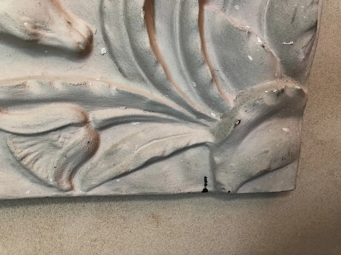 Placa de pared antigua con detalles en relieve, con decoraciones suaves y patrones elegantes.