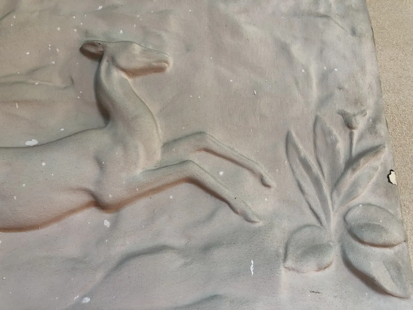 प्राचीन दीवार प्लेट पर हिरण की राहत और पौधे