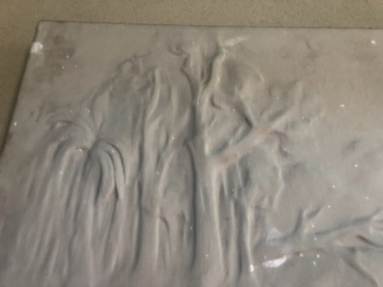 Plaque murale ancienne avec détails en relief et texture.