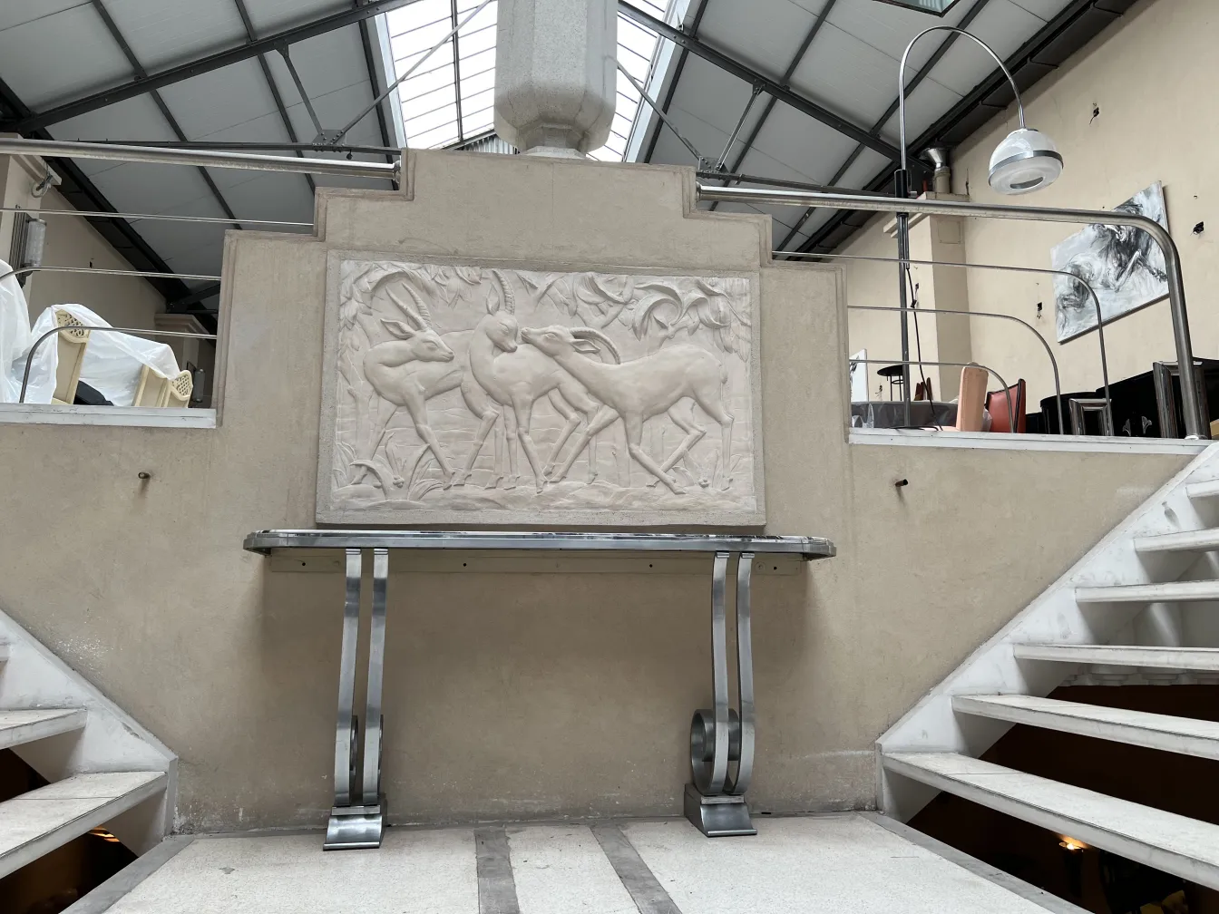 Placca a muro antica con rilievo di cervi in un contesto moderno.