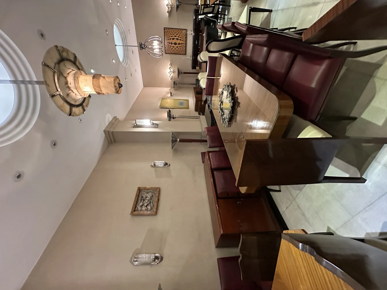 لوحة جدارية قديمة مزينة في غرفة طعام أنيقة تحيط بها الطاولات والكراسي.