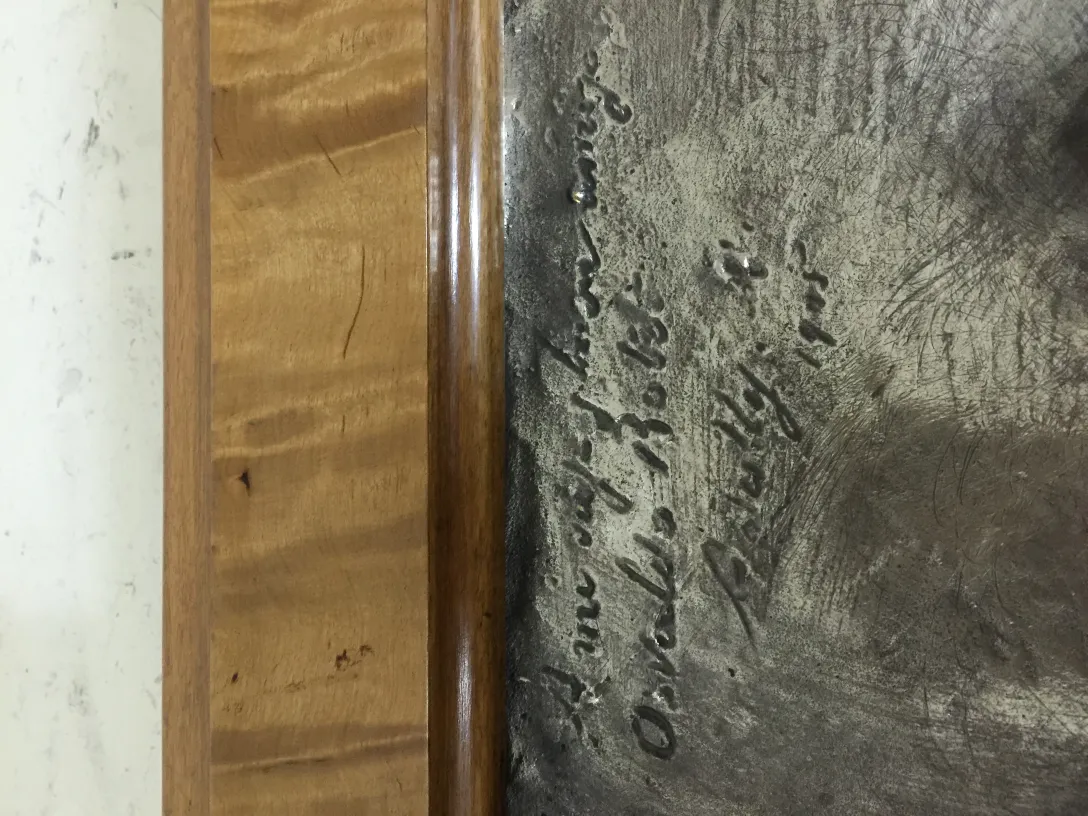 Placa de pared antigua con inscripcion visible en la superficie