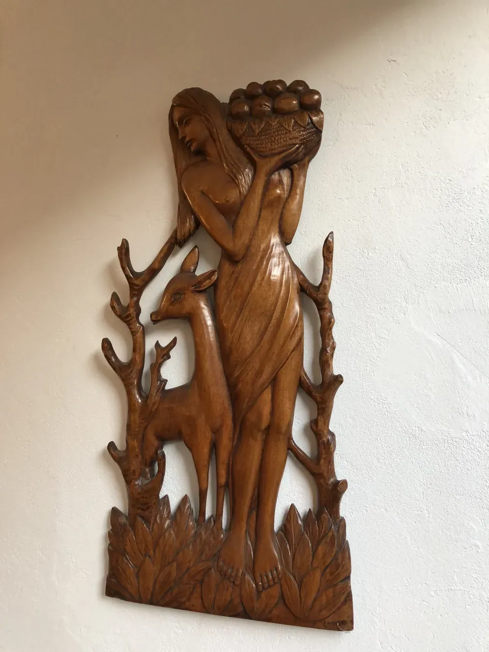 escultura antigua de mujer y ciervo con cesta