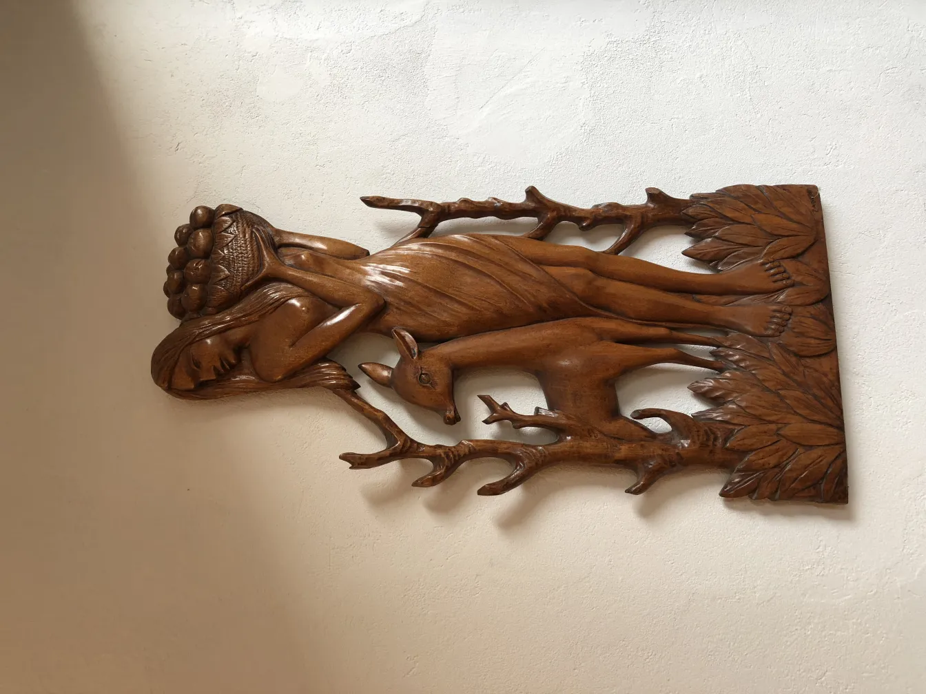 Старинная настенная панель с рельефом человеческой фигуры и оленя.