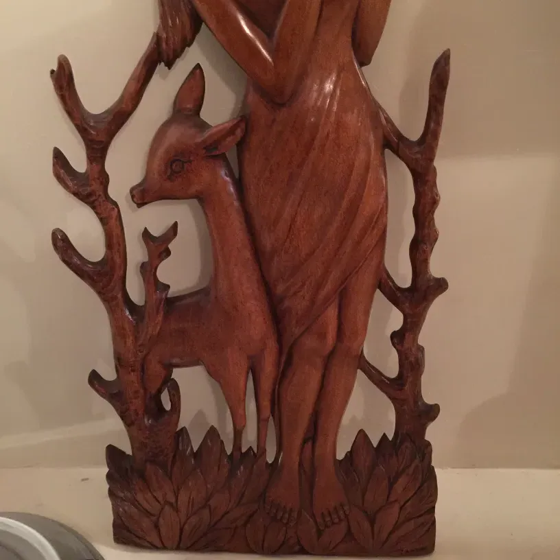 antique wall plate showing a deer figure and branches