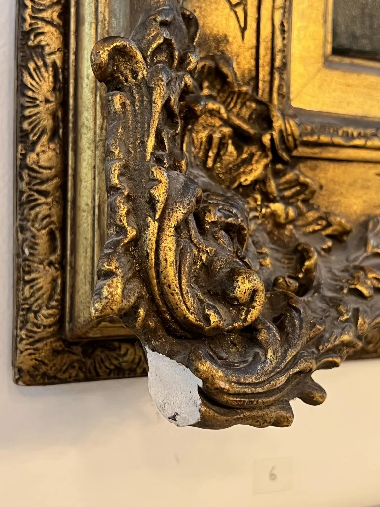 details of a gilded frame of an antique painting, with decorative ornaments