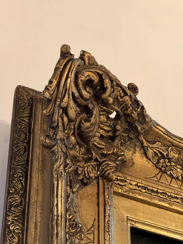 Antique painting with a golden frame featuring intricate details.