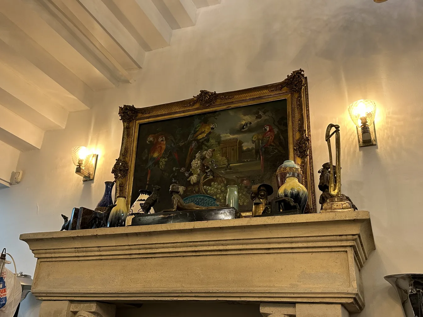 Peinture ancienne encadrée avec des oiseaux et des fleurs, dans un cadre rustique.