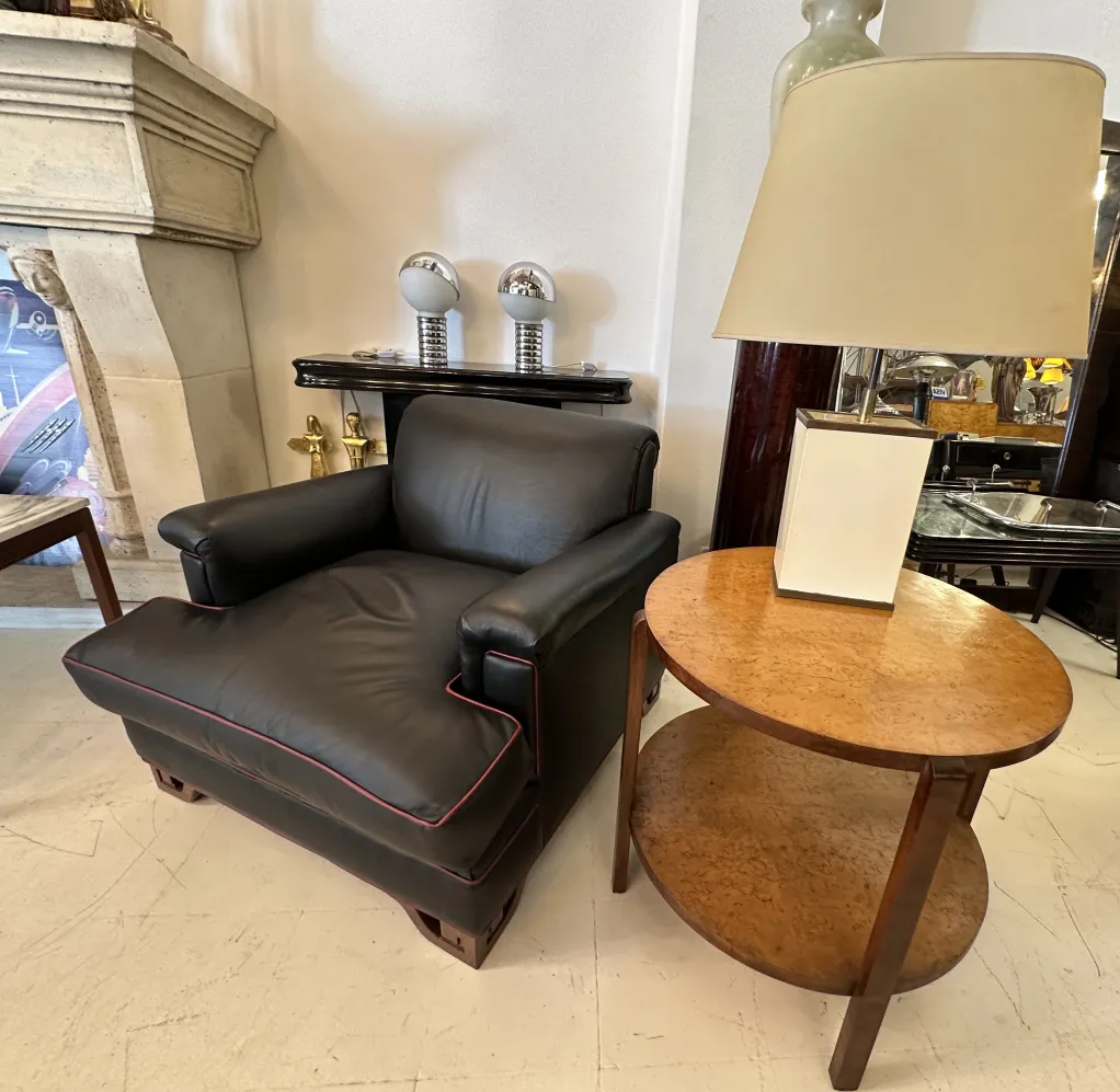 deux lampes de table anciennes à côté d'un fauteuil noir et d'une table