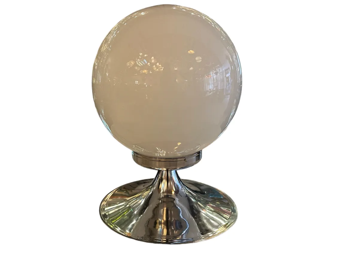 2 antique table lamps with round base and spherical shade, illuminated setting.