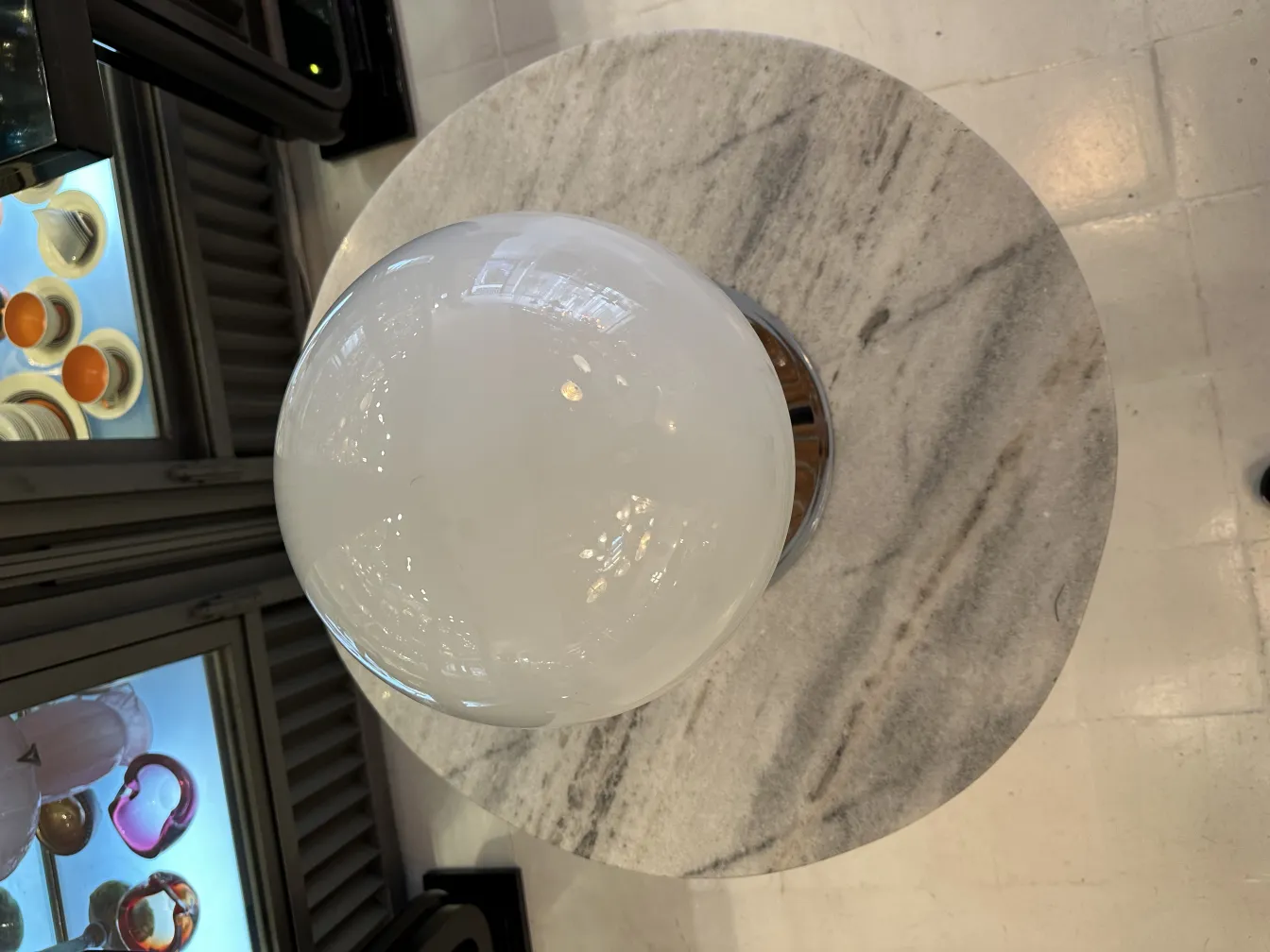 Dos lámparas de mesa antiguas con diseño redondo sobre una mesa de mármol en un entorno acogedor