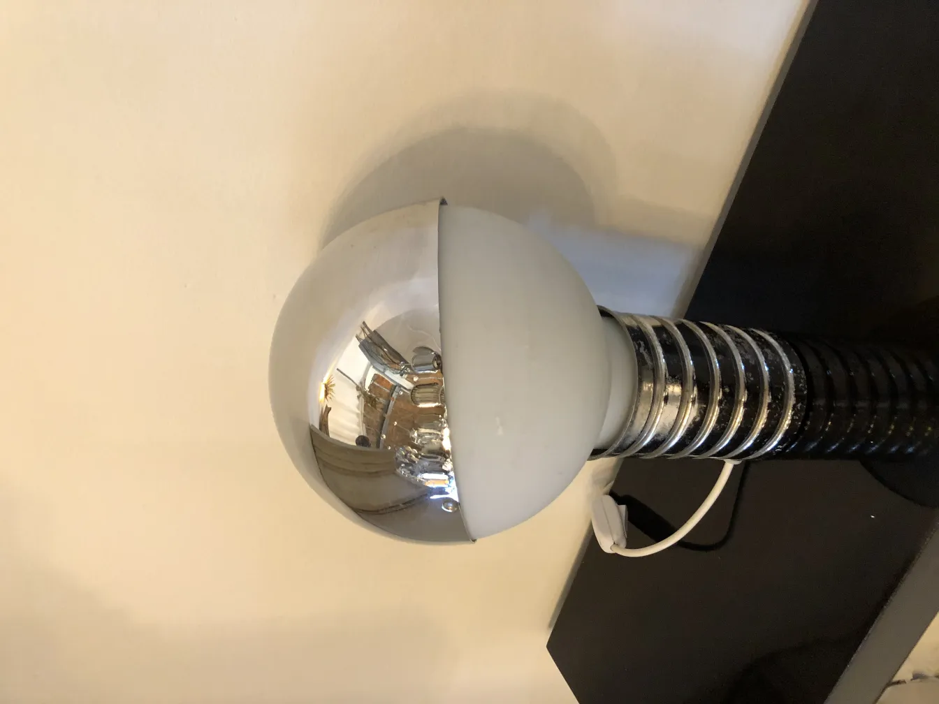 2 lampade da tavolo antiche con sfera lucida e base nera, in un ambiente minimalista.