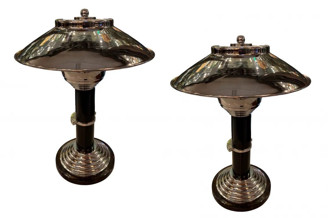 Duas lâmpadas de mesa antigas com cúpula brilhante e base detalhada, ambientadas em um ambiente clássico.