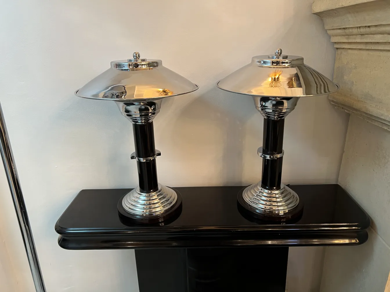 two antique table lamps with a sophisticated design, on a black surface