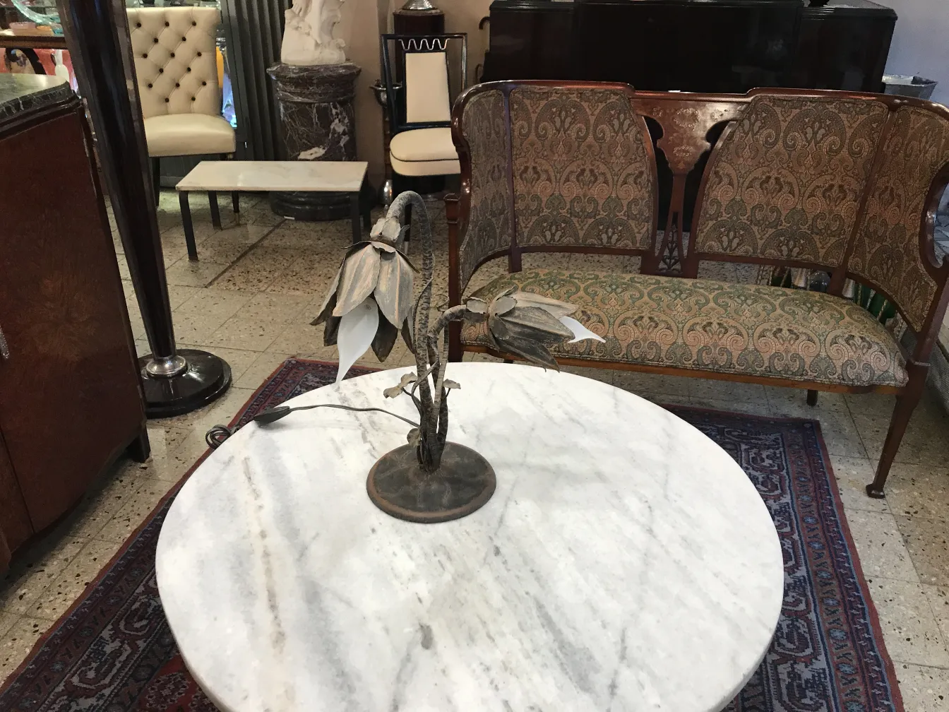 lampada da tavolo antica con base floreale su tavolo in marmo