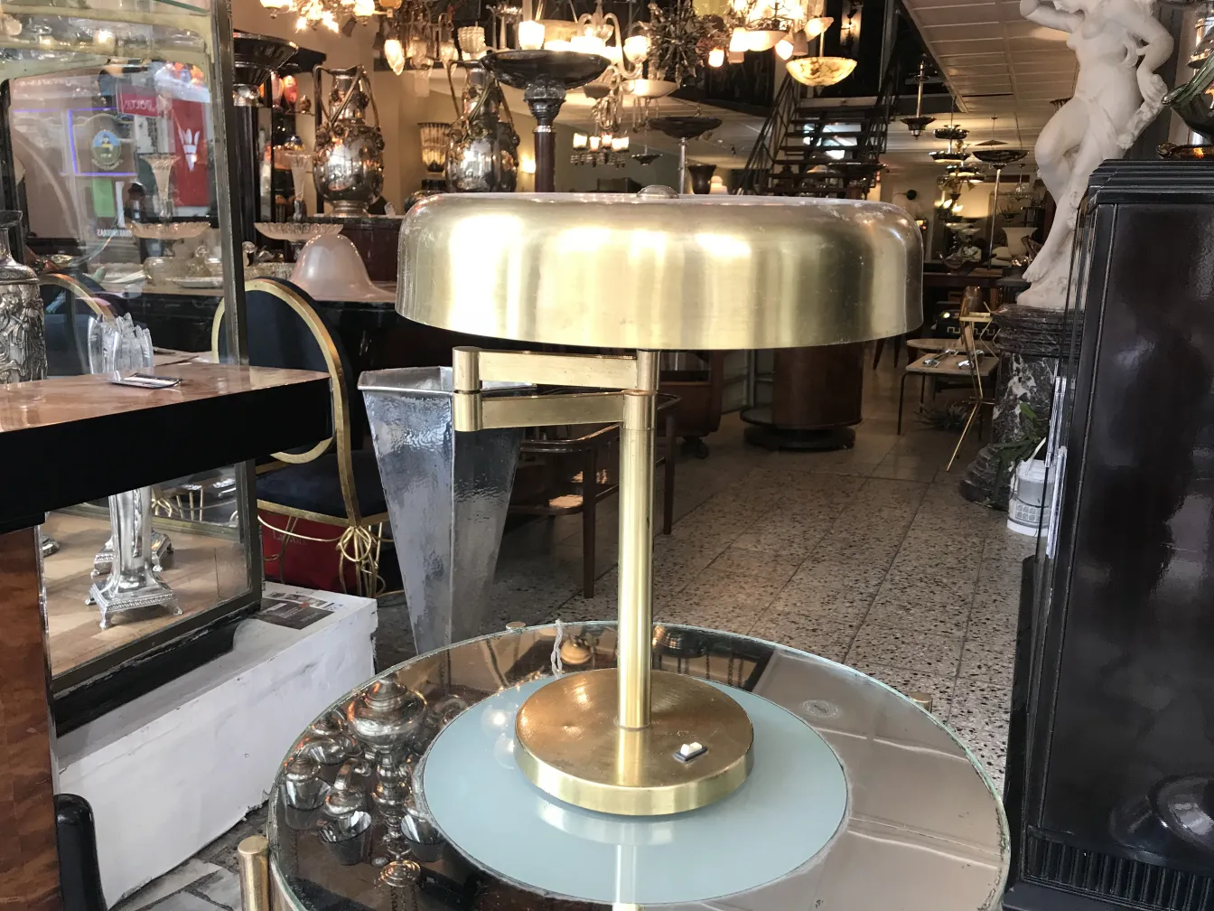 Duas lampadas de mesa antigas com acabamento dourado e base redonda, em um ambiente decorativo elegante.