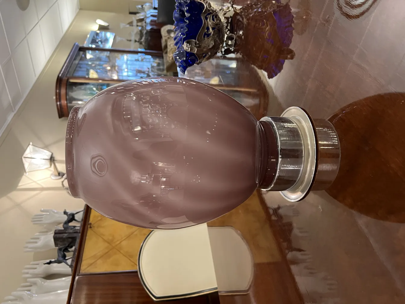 две антикварные настольные лампы с керамической основой на фоне элегантного интерьера с витринами