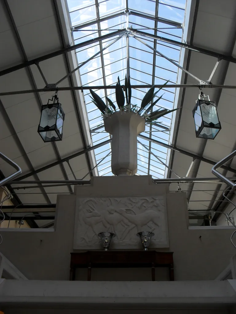 Deux lampes de table anciennes embellissant un espace bien éclairé avec un grand plafond en verre.