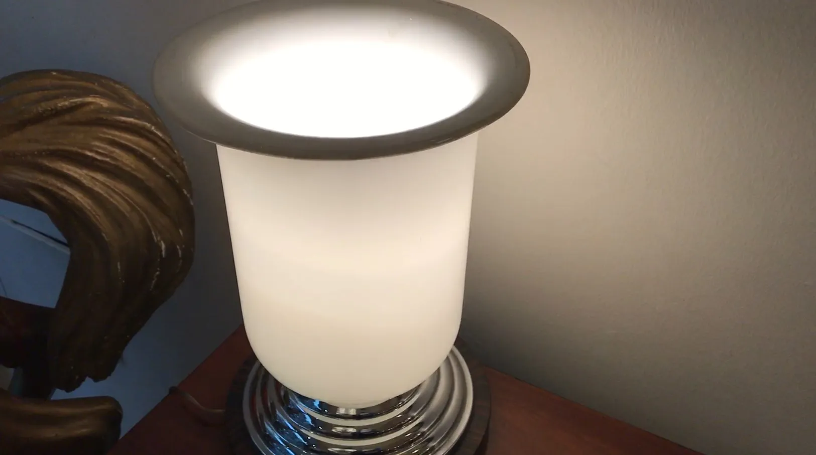 Antique white table lamp with glossy base in a cozy setting.