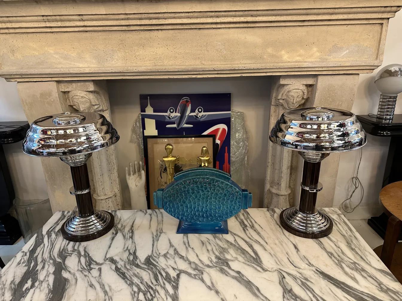 Dos lámparas de mesa antiguas con un diseño elegante, sobre una mesa de mármol.