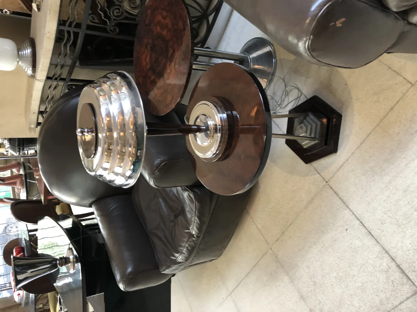 Due lampade da tavolo antiche con base rotonda e paralume elegante. Posizionate accanto a una poltrona in pelle.