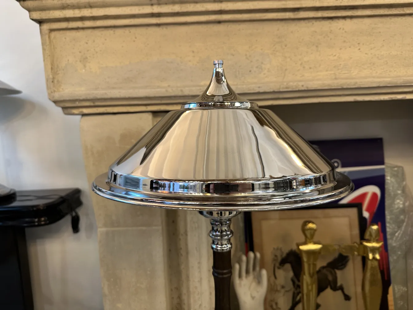 Vista detallada de dos lámparas de mesa antiguas con sombras reflectantes, en un ambiente clásico. 