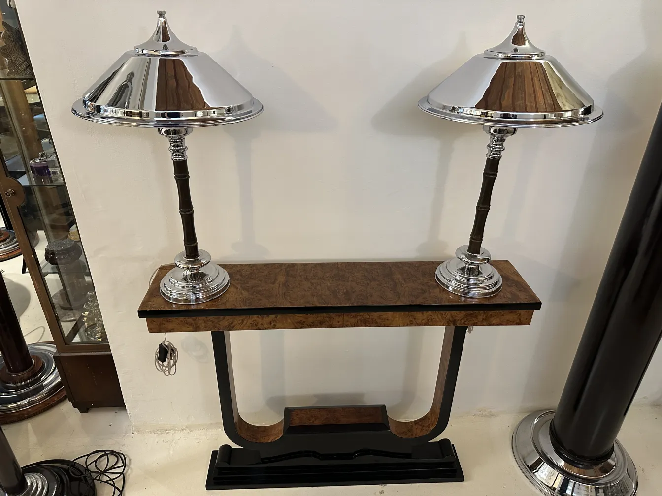 Front view of 2 antique table lamps with elegant bases in a classic setting.