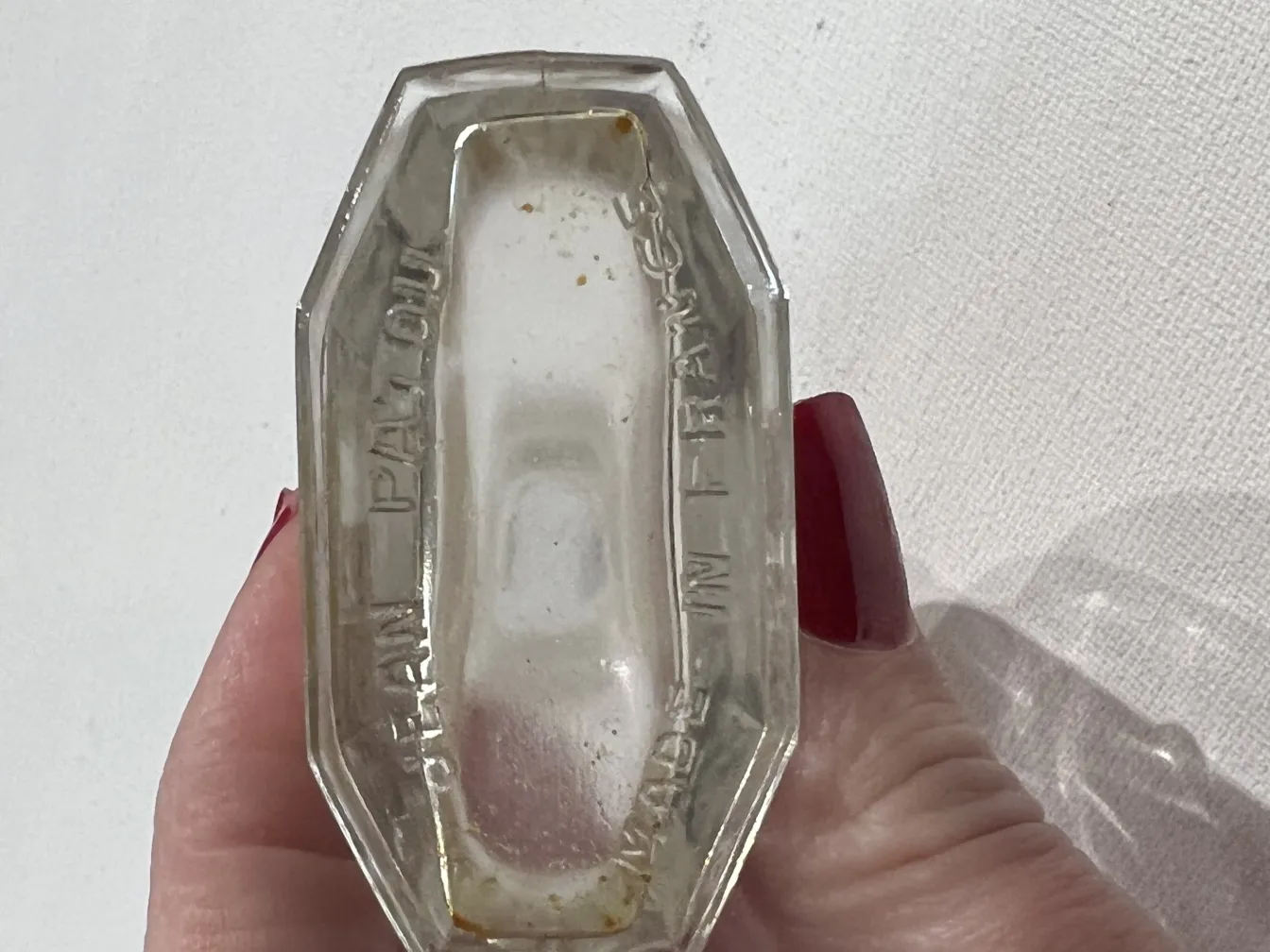 Frasco de perfume antigo em forma octagonal com inscrição.