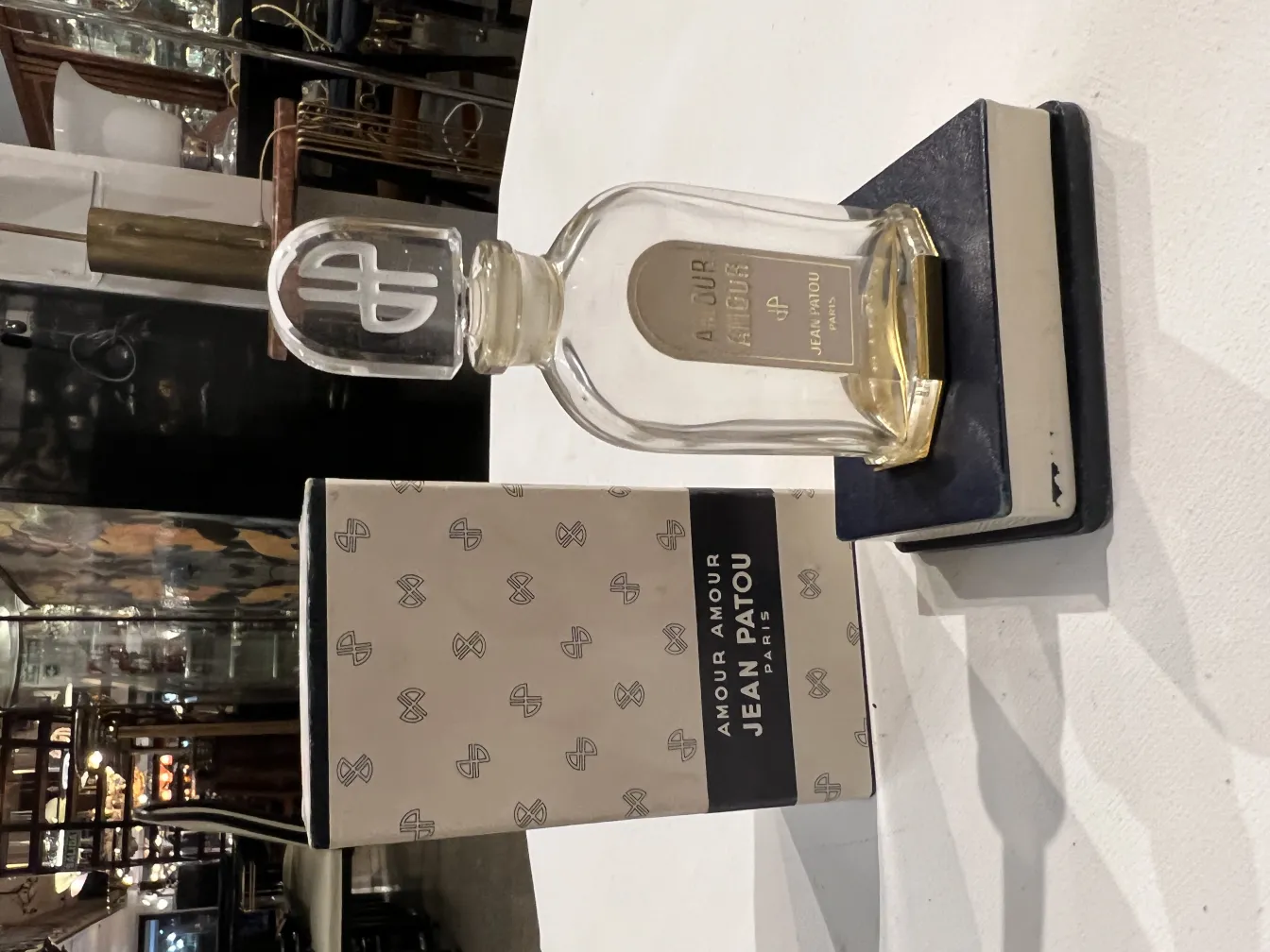 Flacon de parfum ancien avec bouchon dans un cadre moderne.