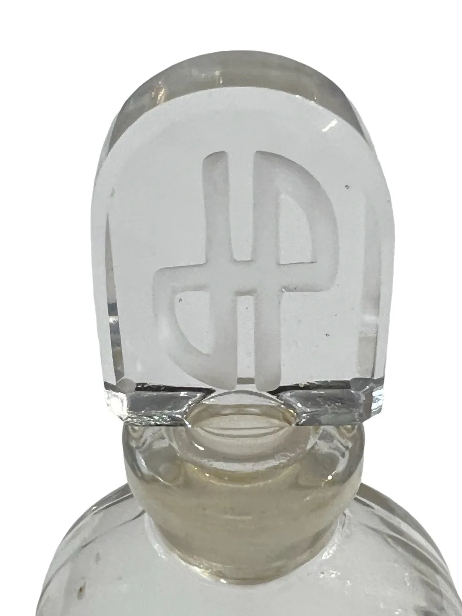 Frasco de perfume antiguo con tapa de cristal, elegante y nostálgico.