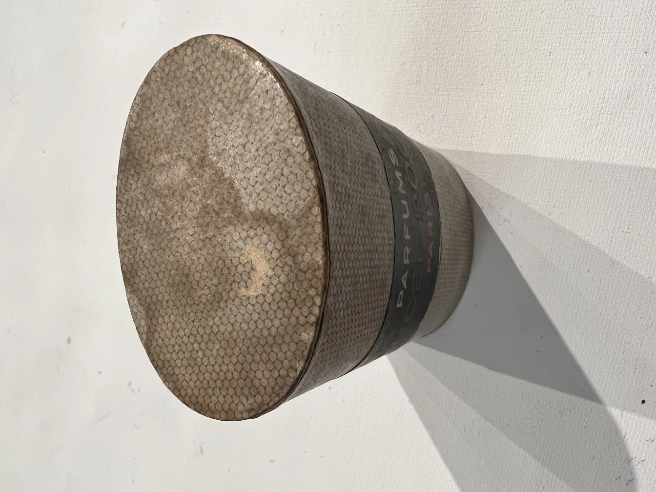 Античный флакон для духов с уникальными деталями и округлой формой в простом окружении.