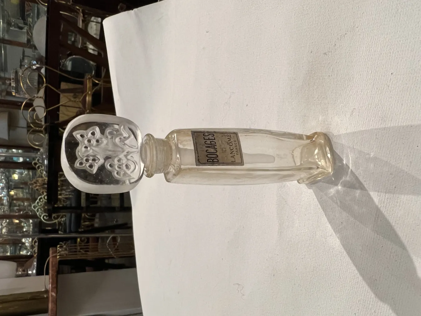 flacon de parfum ancien avec design décoratif et étiquette visible