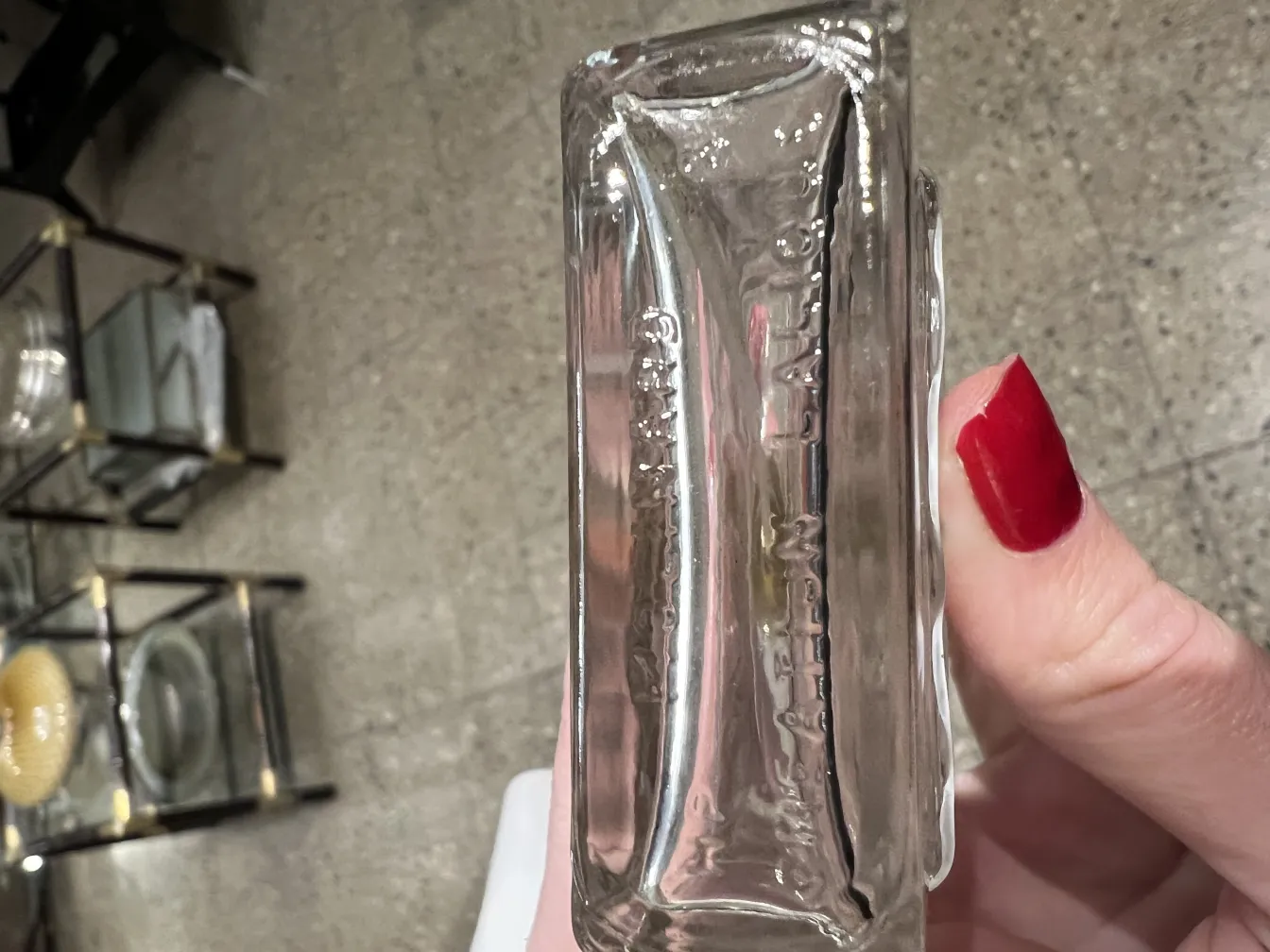 frasco de perfume antiguo en un entorno elegante con mesas de cristal