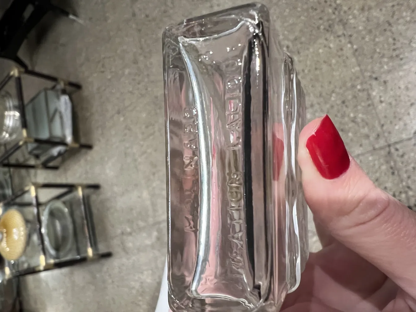 antique transparent perfume bottle with elegant detail, background with decorative items