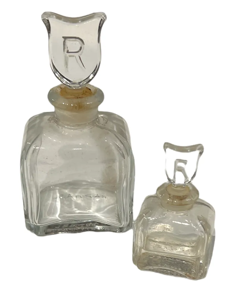 Deux flacons de parfum anciens, l'un plus grand que l'autre avec des bouchons décoratifs