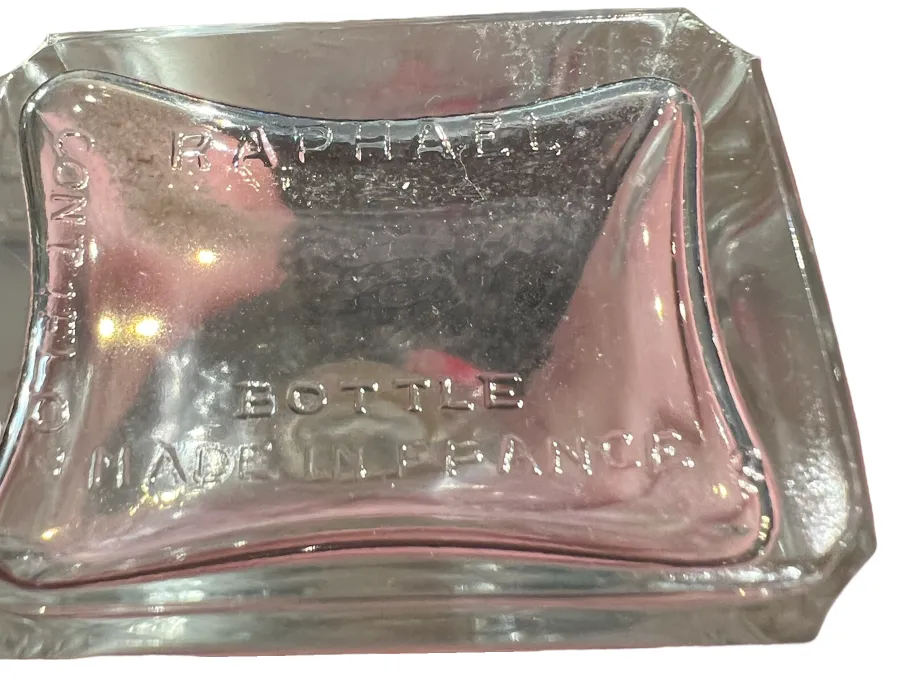 Frasco de perfume antiguo de Raphael, transparente y elegantemente diseñado con detalles distintivos