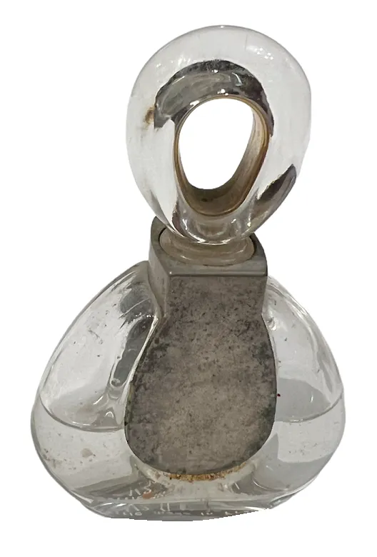 frasco de perfume antiguo con forma elegante y tapa distintiva, decorado con detalles sutiles