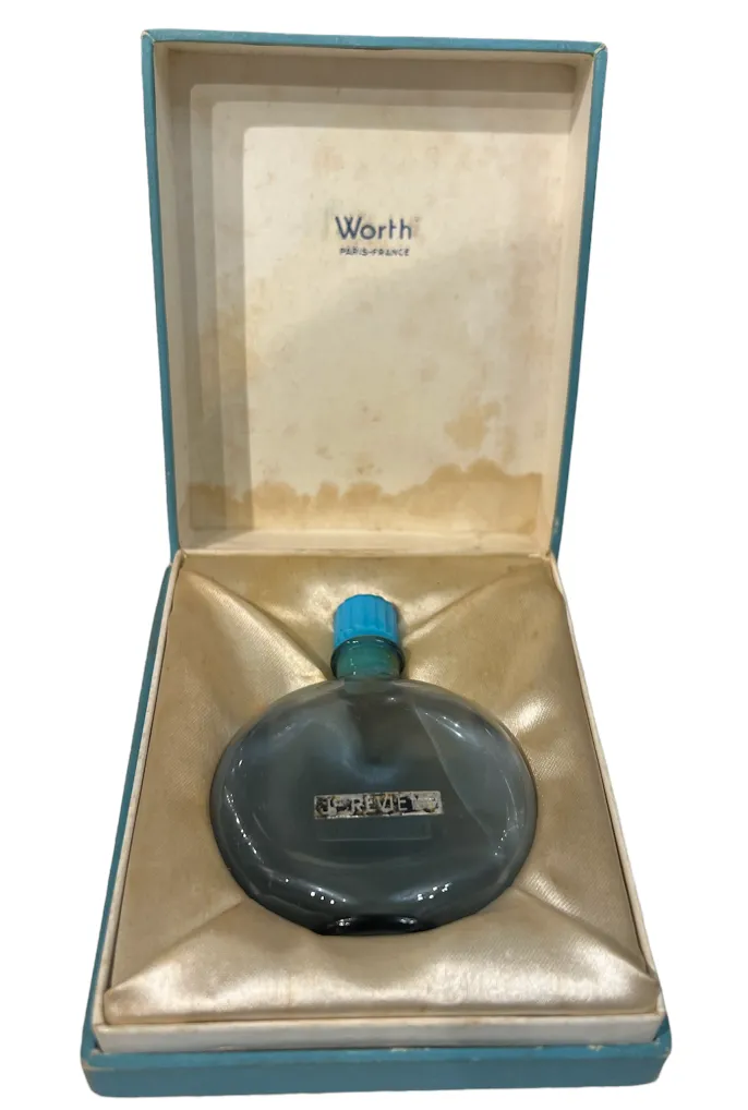 Antique round perfume bottle with a blue cap in an elegant box.