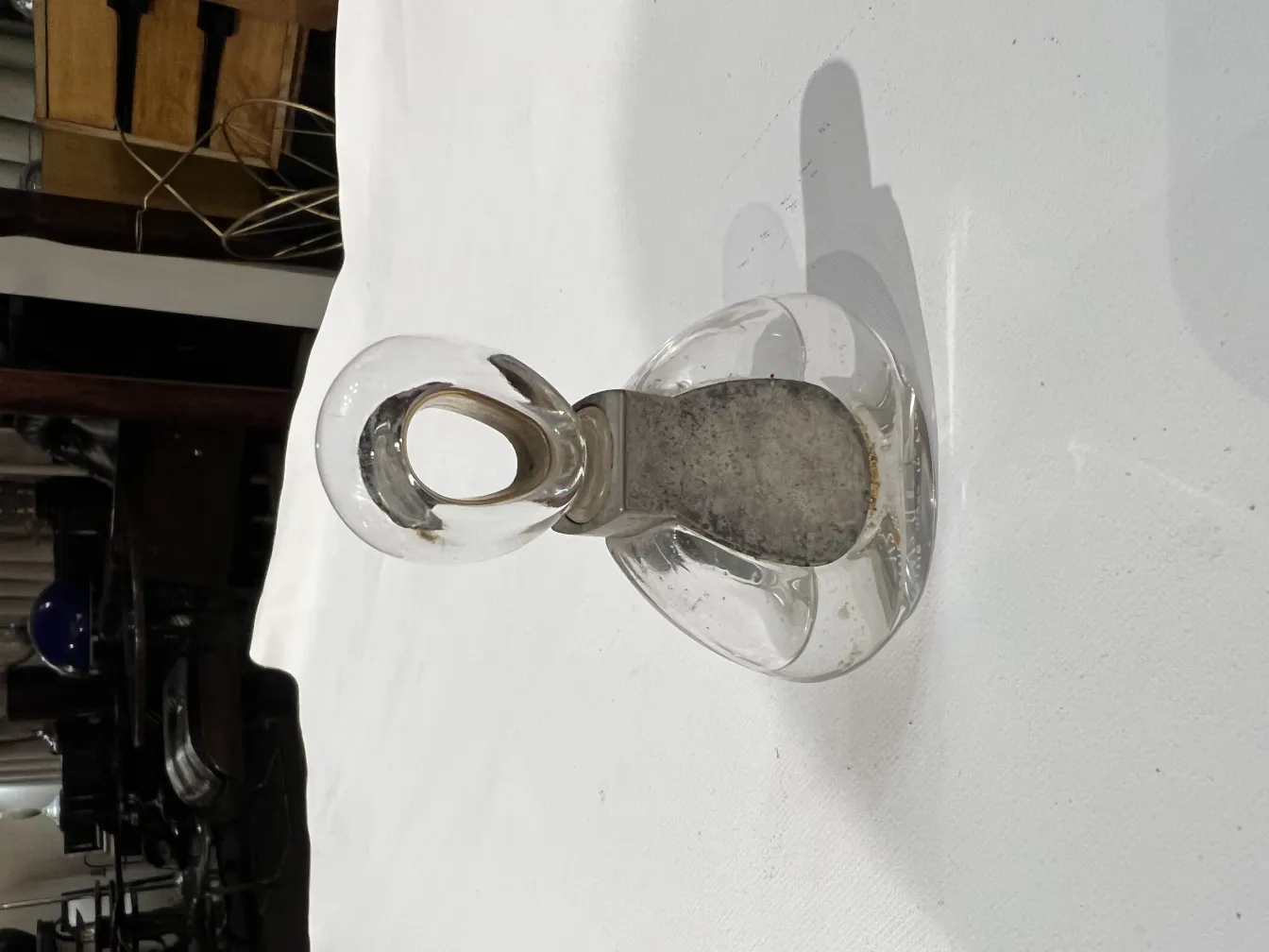 flacon de parfum ancien avec un design élégant et un bouchon en forme d'anneau sur fond blanc