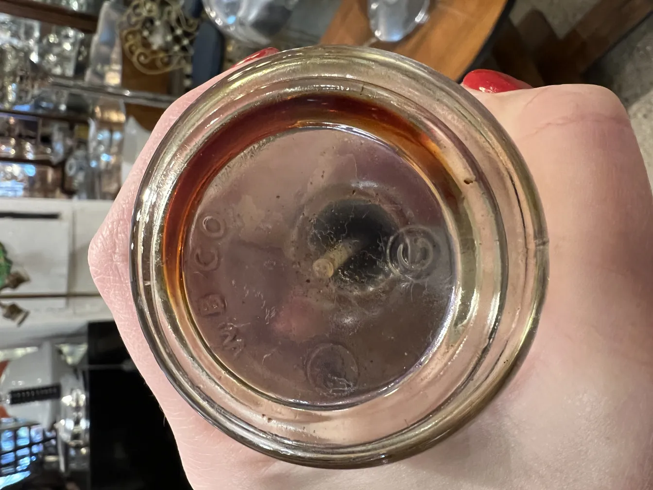 古董香水瓶的顶部，里面有深色液体。