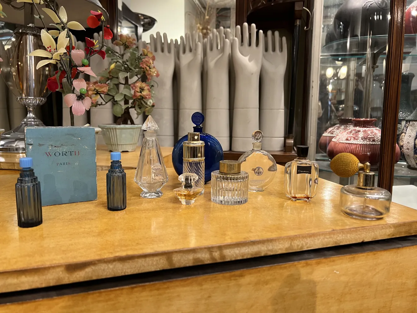 Plusieurs flacons de parfum anciens sur une table en bois.