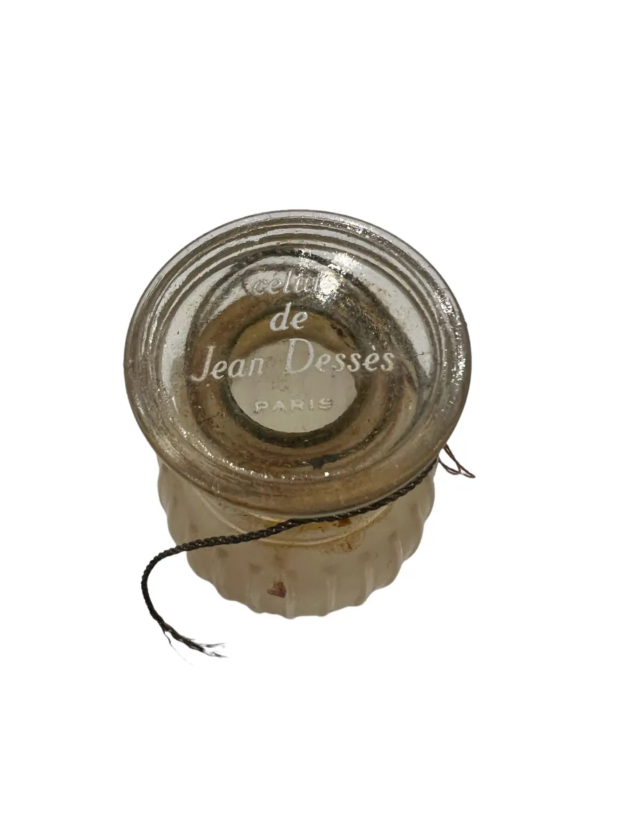 Frasco de perfume antiguo con diseño elegante y detalles claros.