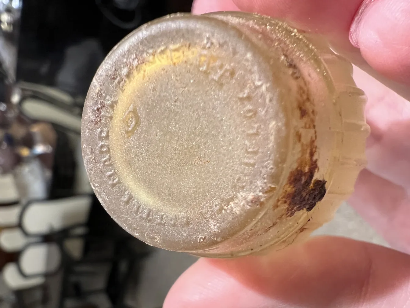 antique perfume bottle with decorative details and visible dirt