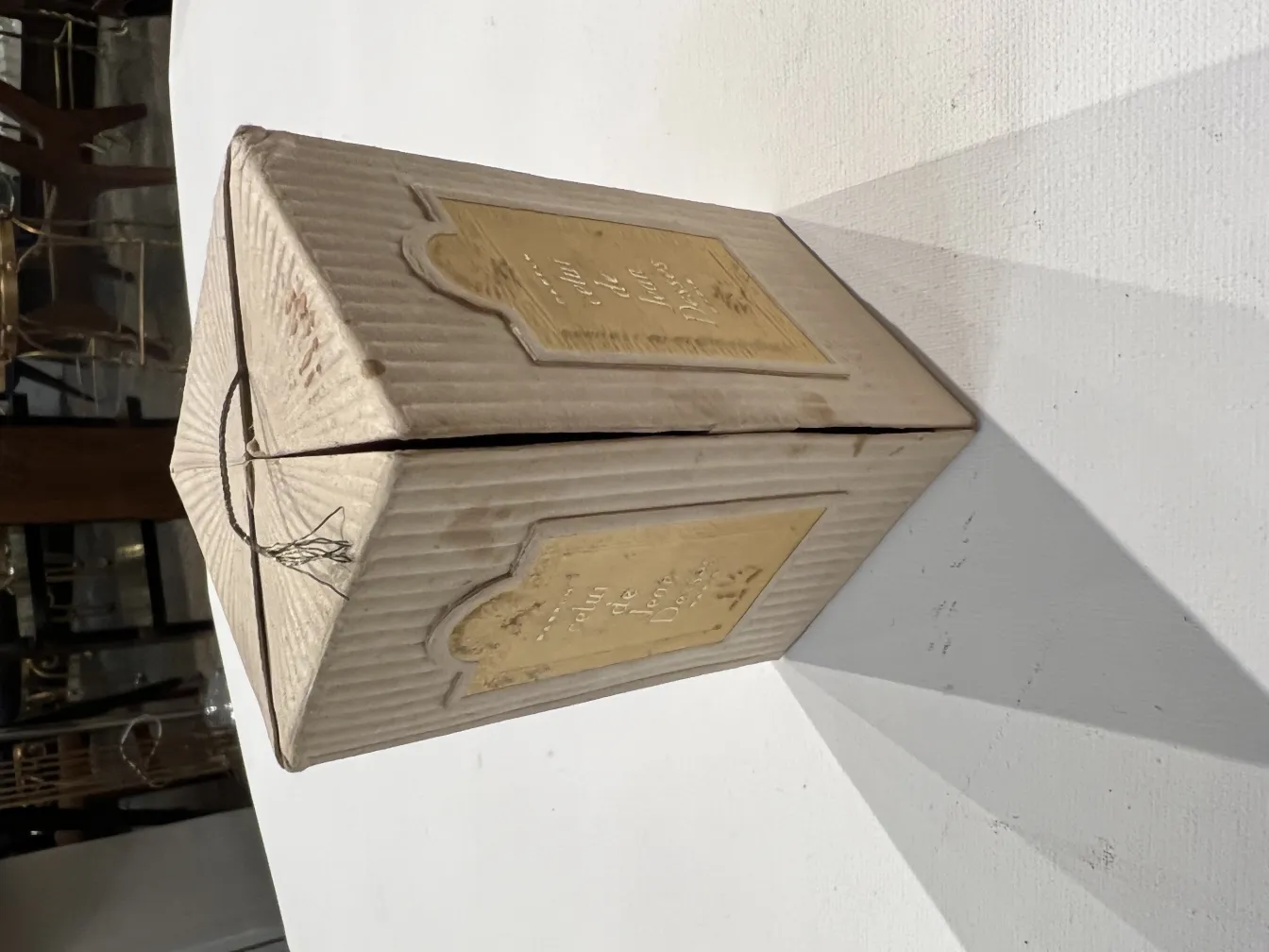 Frasco de perfume antigo com rotulagem dourada e design clássico