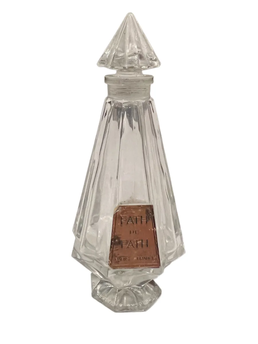 flacon de parfum antique avec capuchon conique, décorations facettées, sur fond neutre