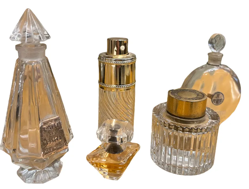 four antique perfume bottles in various shapes and sizes on white background