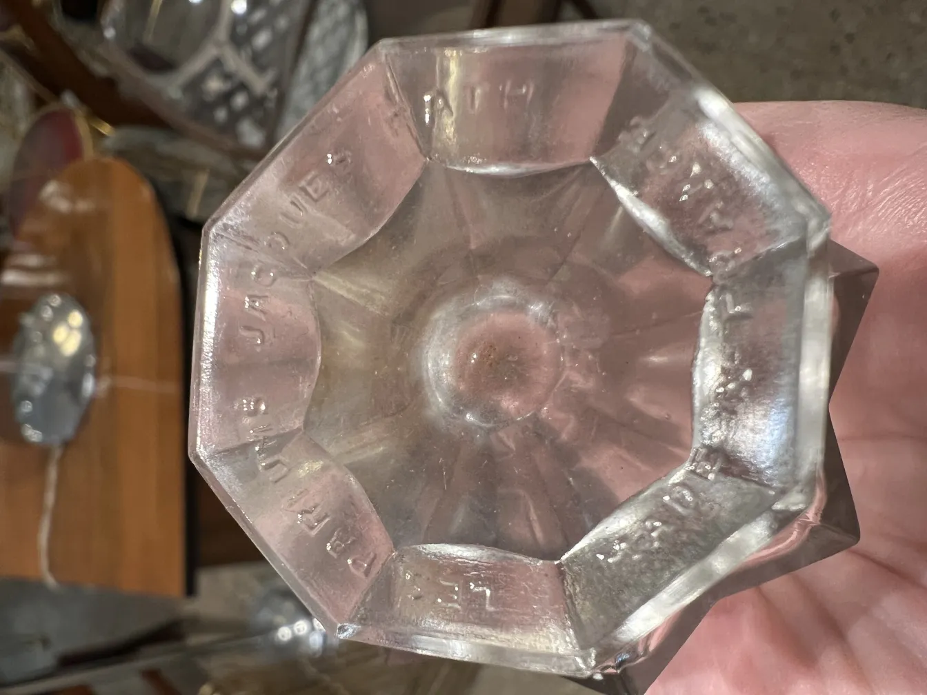 flacone di profumo antico con design in vetro ottagonale e dettagli incisi.